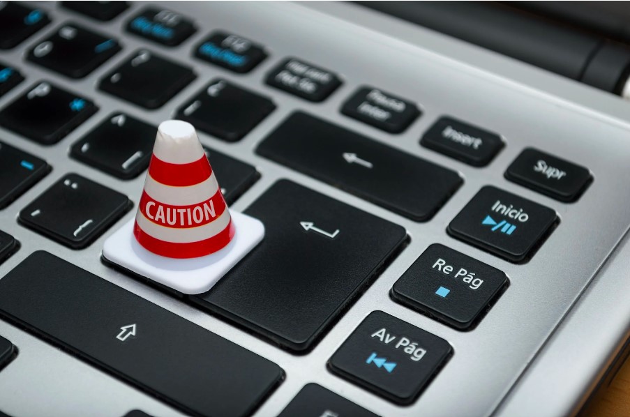 Tiny caution cone on a laptop keyboard Tiny caution cone on a laptop keyboard
